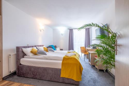 a bedroom with a large bed with a yellow blanket on it at Nova Fala in Łeba