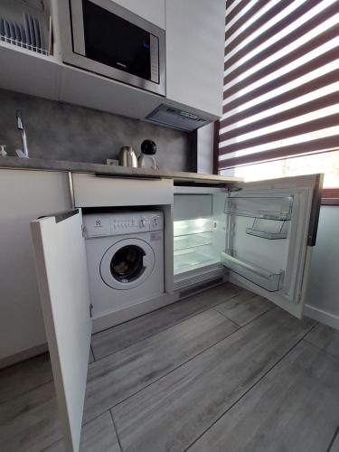 uma cozinha com máquina de lavar e secar roupa em Molino Apartamentai em Palanga