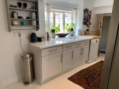 cocina blanca con fregadero y ventana en Quintessential Cottage near Bath, Grade 2 Listed., en Paulton
