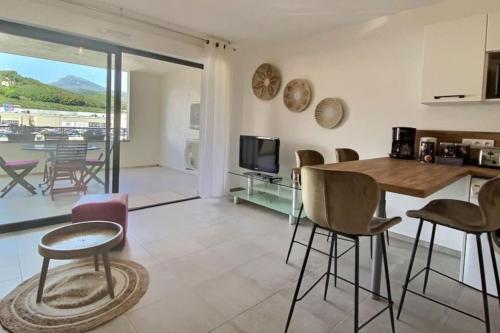 cocina y sala de estar con mesa y sillas en T2 neuf avec belle terrasse proche plage, en Folelli
