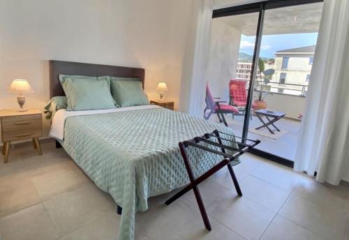 - une chambre avec un lit et un balcon dans l'établissement T2 neuf avec belle terrasse proche plage, à Folelli