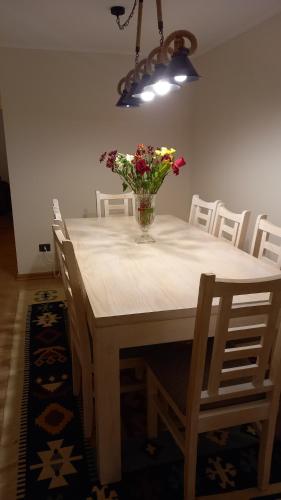 a dining room table with a vase of flowers on it at Bienvenidos a Valdivia in Valdivia