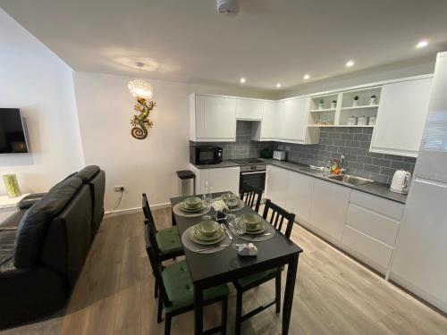 a kitchen and living room with a table and chairs at Modern 2 bedroom apartment, with car parking. in Oldland Common