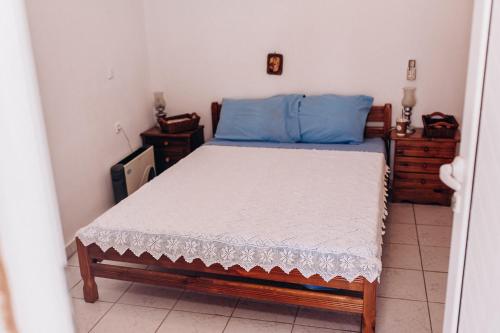 a bedroom with a bed with blue and white sheets at HILL SANDALI HOUSE in Sitia