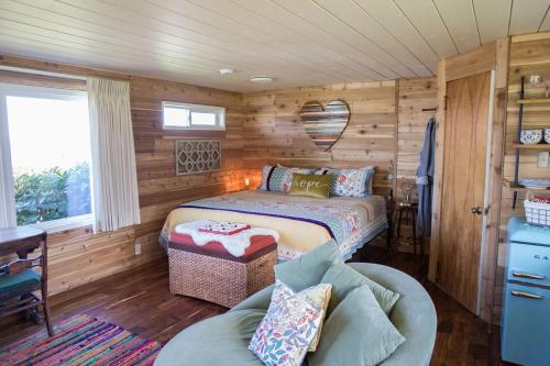 um quarto com uma cama e um sofá num quarto em Dungeness Bay Cottages em Sequim