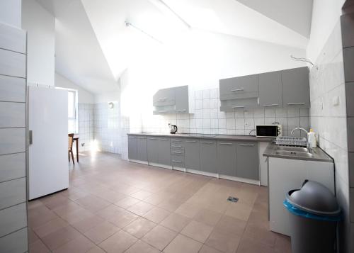 a kitchen with white cabinets and a white refrigerator at Pokoje Horyzont in Jarosław
