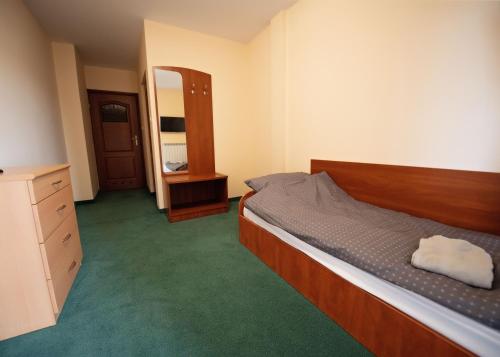 a bedroom with a bed and a dresser and a mirror at Pokoje Horyzont in Jarosław