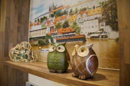 two owl figurines sitting on a shelf next to a painting at 輕旅小站 Soft Travel Hostel in Taitung City
