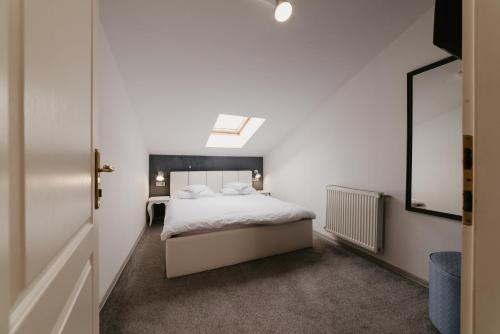 a bedroom with a white bed and a skylight at Meteor Central in Cluj-Napoca