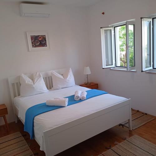 a bedroom with a white bed with towels on it at My Mediterranean Villa with Huge Garden and own Parking in Lumbarda