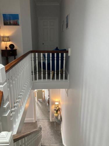 a hallway with a stairway with a stair case at Bentley Lodge in Torquay