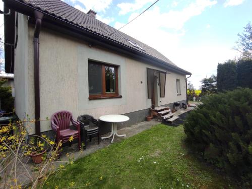 a small house with a table and chairs in the yard at Apartamenty z ogrodem nr 2 typu studio in Mrągowo