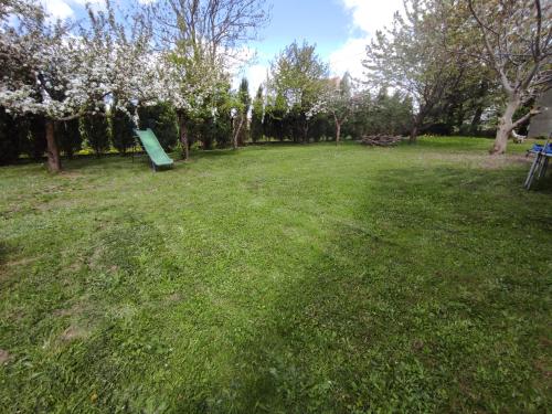 a park with a green sign in the grass at Apartamenty z ogrodem nr 2 typu studio in Mrągowo
