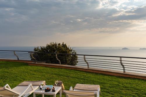 a group of chairs and a table with a view of the ocean at Golfo dei Poeti Relais & Spa in Ameglia