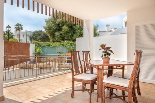 patio con mesa de madera y sillas en el balcón en Apartaments Vaixell en Santanyí