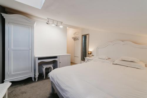 a white bedroom with a white bed and a fireplace at Meteor Central in Cluj-Napoca
