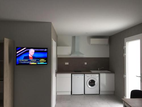 a kitchen with a tv hanging on the wall at Résidence du Lac - Proximité Le PAL in Bourbon-Lancy