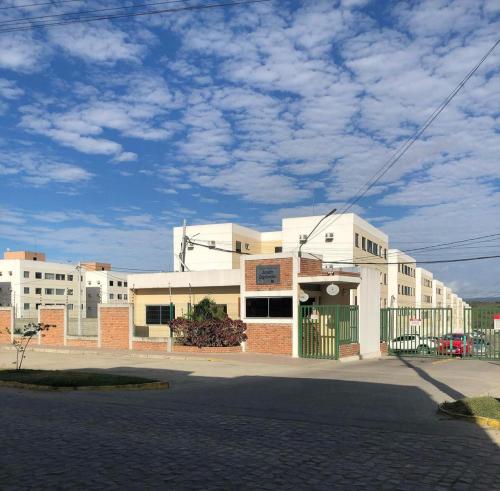 Biały budynek z zieloną bramą przed nim w obiekcie Apartamento Mobiliado para seu conforto w mieście Caruaru