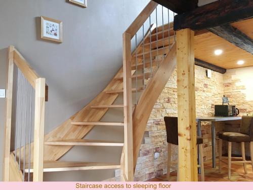eine Holztreppe in einem Zimmer mit Ziegelwand in der Unterkunft Maison de la Sauer - Bed and Breakfast | Chambre d’hôtes | Ferienhaus in Munchhausen