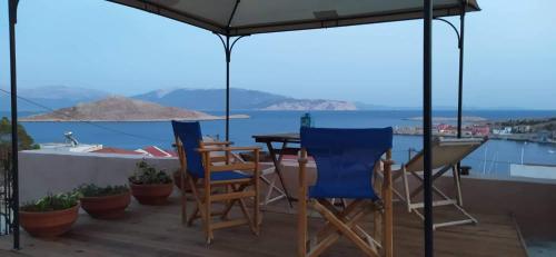 einen Tisch und Stühle auf einer Terrasse mit Blick auf das Wasser in der Unterkunft Marina Castellana Studios II in Chalki