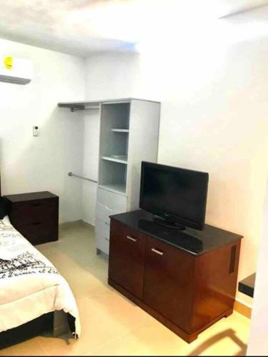 a bedroom with a tv on a dresser with a bed at Departamento hermoso en guadalupe in Monterrey