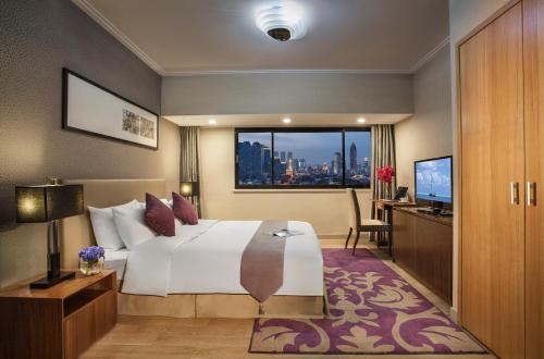 a hotel room with a bed and a window at Somerset Olympic Tower Tianjin in Tianjin