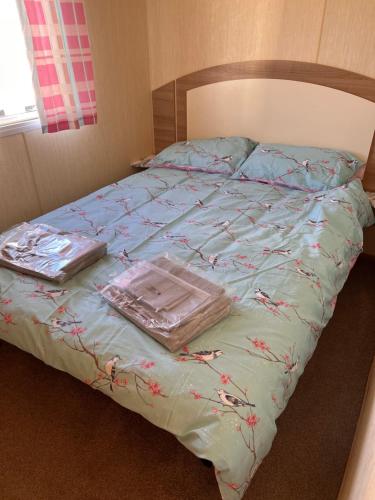 a bed with two plastic containers on top of it at Evans Whitehouse Caravan Towyn in Abergele