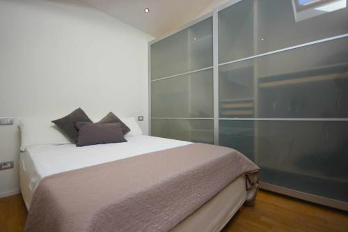 1 dormitorio con 1 cama y una gran pared de cristal en Case VR Holiday Attico di Lino en Verona