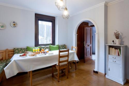 a dining room with a white table and chairs at Casa rural Salomé, Mora de Luna, al lado del río Luna in Vega de Caballeros