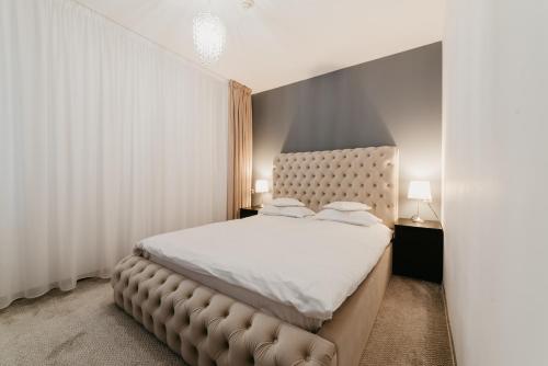 um quarto com uma cama grande e uma cabeceira acolchoada em Meteor Central em Cluj-Napoca