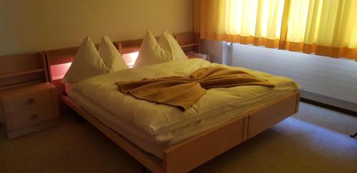 a bed with white sheets and pillows in a bedroom at Haus Duranna - Arosa Rocks in Arosa