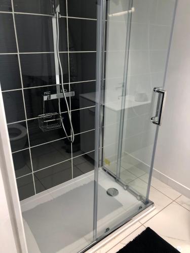 une douche avec une porte vitrée dans une salle de bain dans l'établissement Maison de ville au coeur de Ribérac, à Ribérac