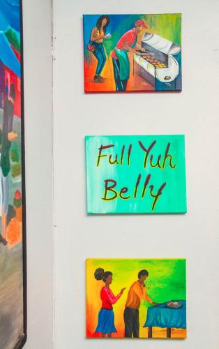 a group of paintings hanging on a wall at Eventuality B&B New Kingston in Kingston
