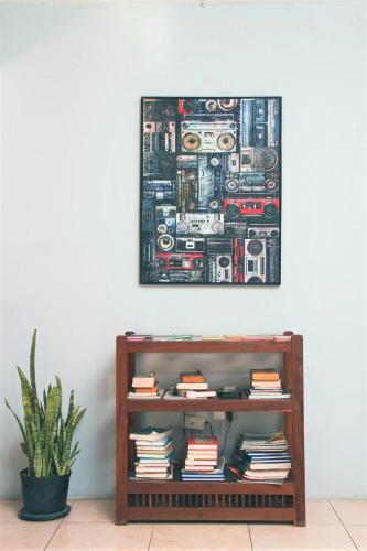 a picture hanging on a wall above a book shelf at Eventuality B&B New Kingston in Kingston