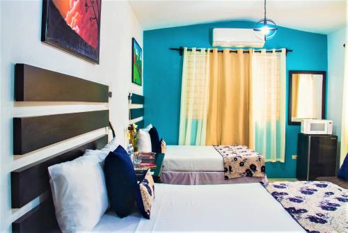 a bedroom with two beds and a blue wall at Eventuality B&B New Kingston in Kingston