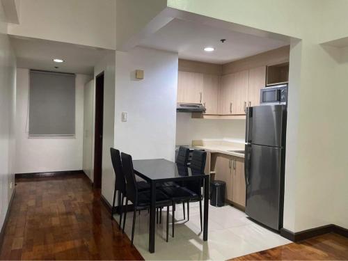 a kitchen with a table and chairs and a refrigerator at Mosaic Tower by LuxuReich in Manila