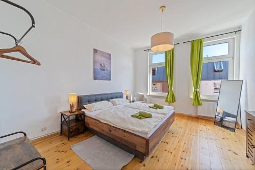 a bedroom with a large bed and two windows at Infinity Stay: Bis zu 6 Personen Zentrumsnah Wassernah Netflix in Wilhelmshaven