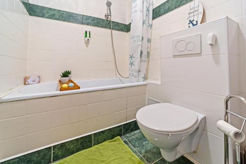 a bathroom with a toilet and a bath tub at Infinity Stay: Bis zu 6 Personen Zentrumsnah Wassernah Netflix in Wilhelmshaven