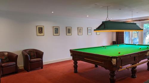 a room with a pool table and two chairs at Greater London Villa in Chelsfield