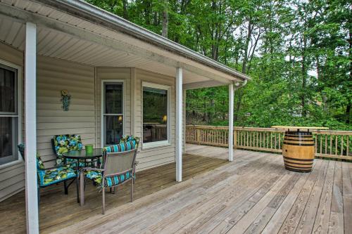 a porch with a table and chairs and a barrel at 17-Seat Theater, Hot Tub and Game Room Ideal Home! in Massanutten