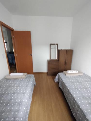 um quarto com 2 camas e piso em madeira em AP confortável para sua família em Palmas