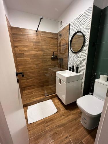 a bathroom with a toilet and a sink and a mirror at Medias Cozy Studio in Mediaş