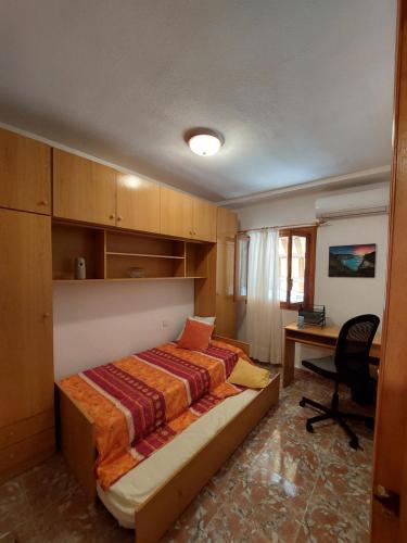 1 dormitorio con cama y escritorio. en Casa Valentino en Santa Pola