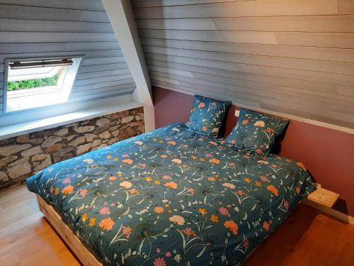 a bedroom with a bed with a floral comforter at Superbe Appart' Bois De Fagne in Malmedy