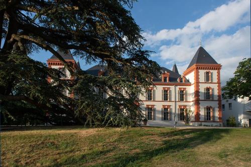 a large white building with a tree in front of it at Résidence DOMITYS CHATEAU CAMAS in Pin-Balma