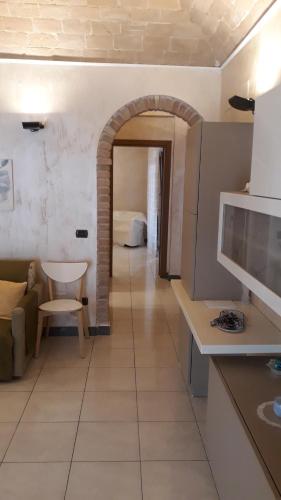 a kitchen with a room with a couch and a table at LA DIMORA DI MARIA in Ortona