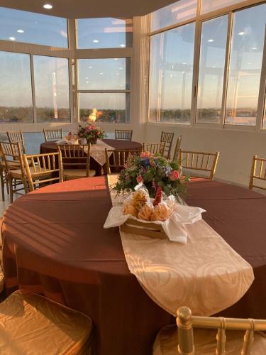 a dining room with two tables with flowers on it at May Palace Hotel  in Tuxpan de Rodríguez Cano