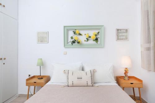ein weißes Schlafzimmer mit einem Bett und zwei Nachttischen in der Unterkunft Olive Tree Cottage in Virós