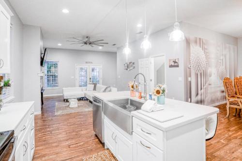 a white kitchen with a sink and a living room at Casa Di Fortune in St. Augustine