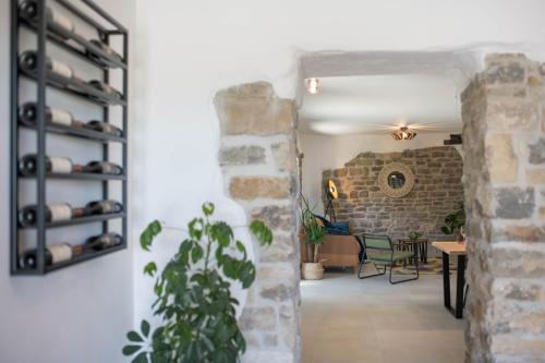 a room with a stone wall and a table and chairs at VILLA FIORE in Marušići